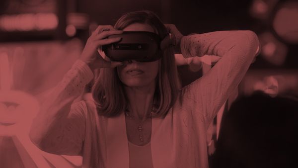 A header image: a woman putting on a Lenovo VRX headset with a crimson overlay.